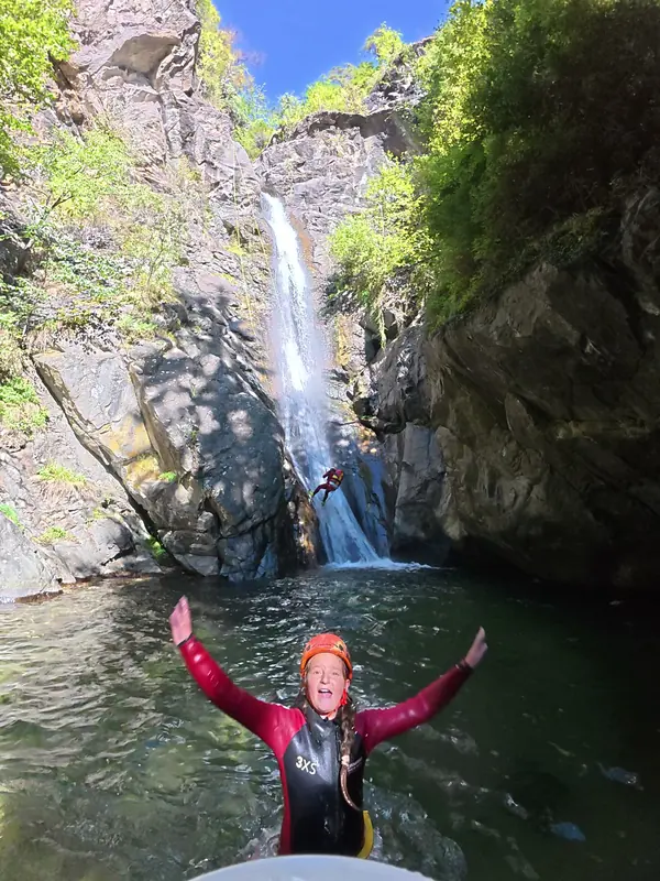 Jubel im Becken unter dem hohen Wasserfall der Auerklamm, dahinter seilt sich jemand ab