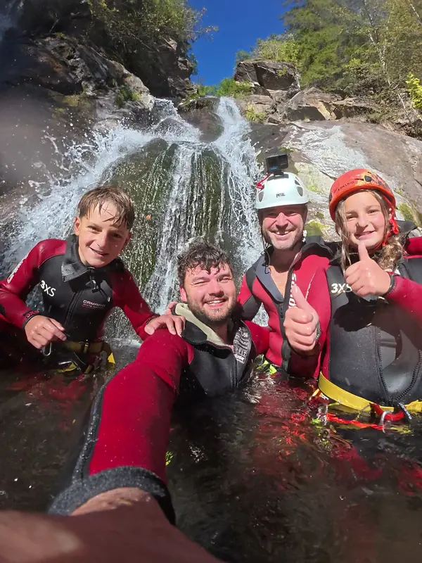Gruppe mit Daumen hoch unter dem Wasserfall in der Auerklamm