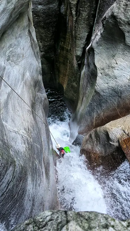 Abseilen durch einen engen Felsspalt im Tessin