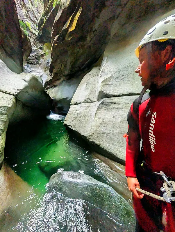 Mit dem Seil in der Hand am Rand eines smaragdgrünen Gumpens im Tessin