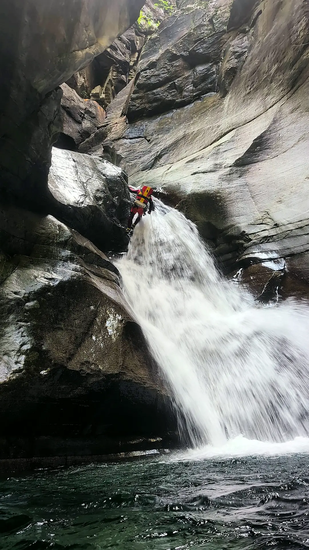 Abseilen mitten im Wasserfall in einer Schlucht im Tessin