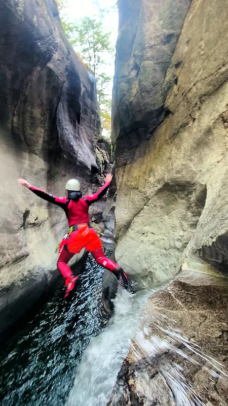 Sprung mit ausgebreiteten Armen in eine enge Klamm im Tessin